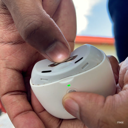 Fingertip on the FYNGE trimmer opening, with the LED light on